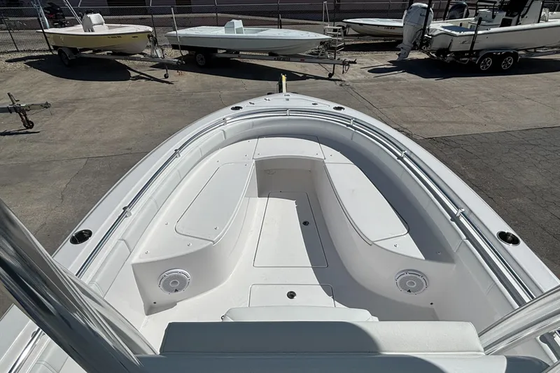 Slide: The Image of 2026 Contender 24 Sport boat, spacious deck view, parked with other boats. - 4