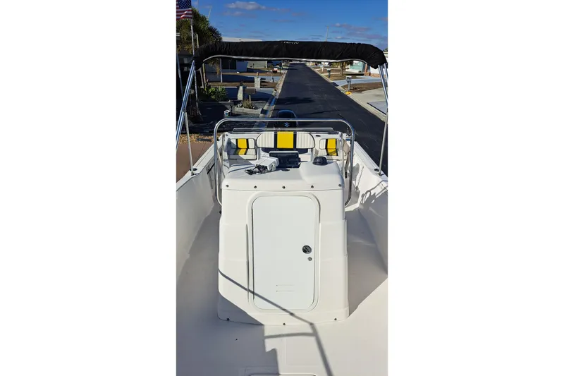 Slide: The Image of 2002 Pro-Line 20 Sport boat interior with console and seating, docked under clear sky. - 4