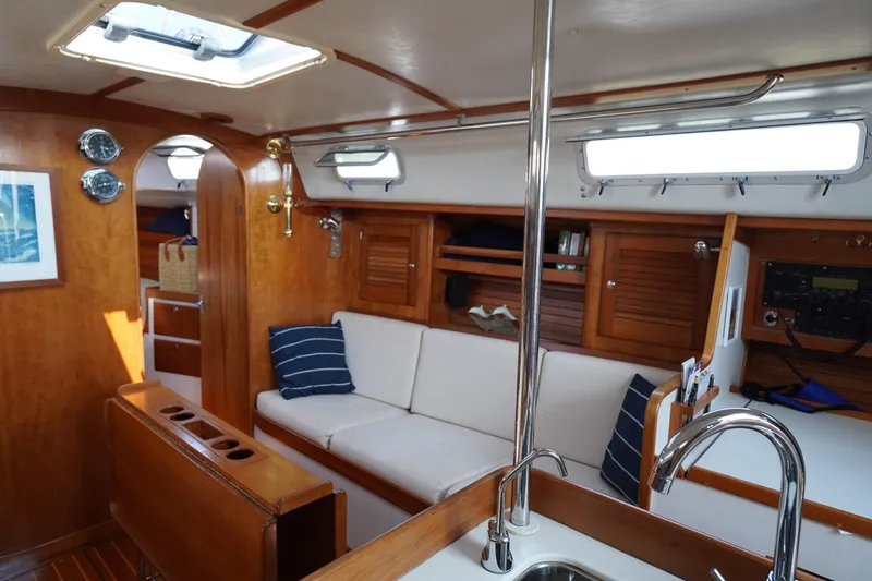 Slide: The Image of Interior of a 1997 J Boats J/42 yacht, featuring cozy sofa and wood finish. - 36