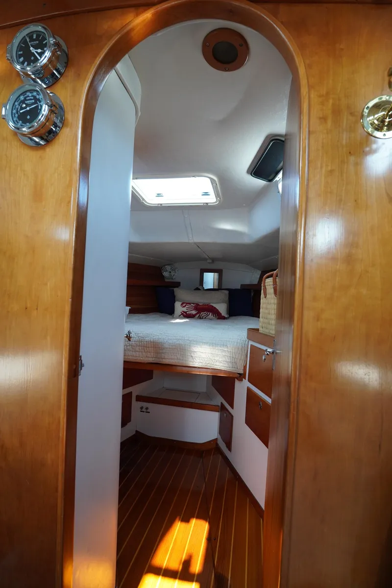 Slide: The Image of Interior view of 1997 J Boats J/42 sailboat cabin with wooden finish and cozy bed. - 44