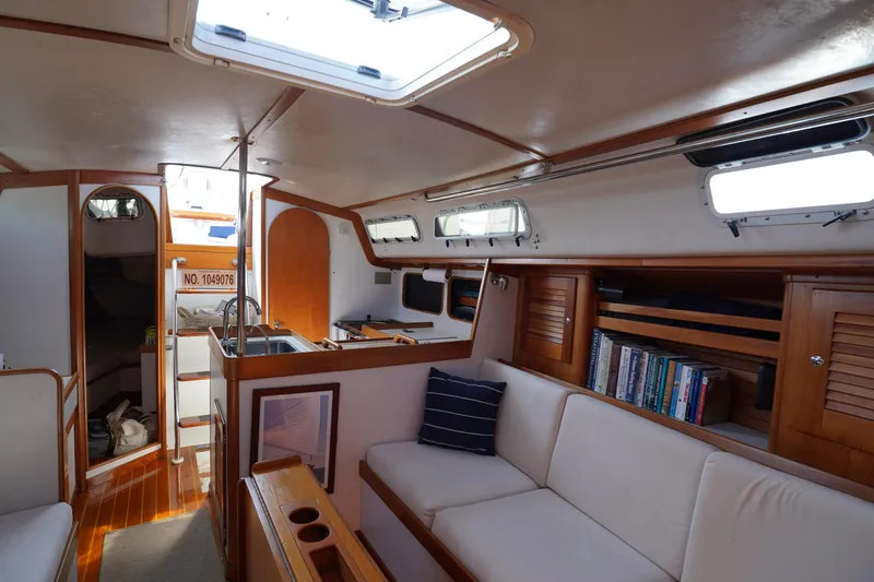 Slide: The Image of 1997 J Boats J/42 yacht bathroom with compact design, featuring sink, toilet, and porthole window. - 49