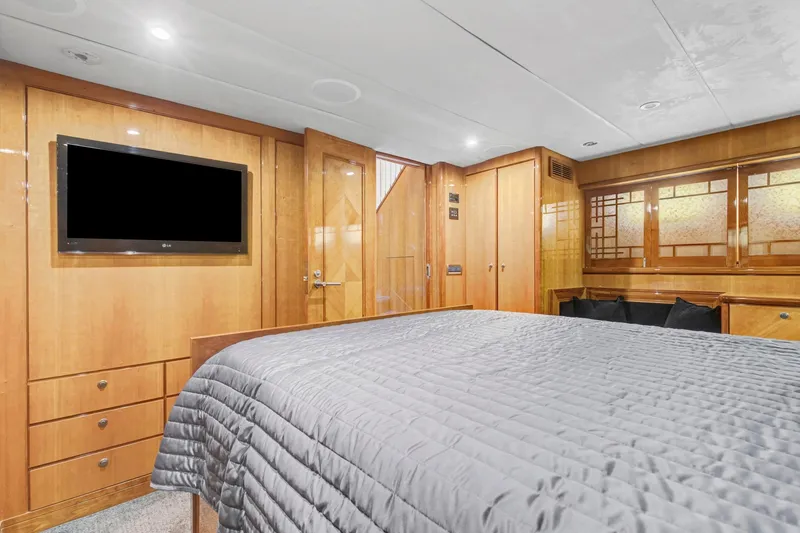 Slide: The Image of Luxurious 2004 Queenship 76 Baretta yacht bedroom with wood paneling and modern amenities. - 13