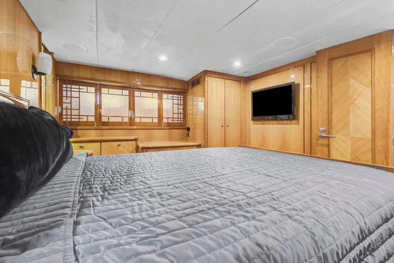 Slide: The Image of Luxurious bedroom interior of 2004 Queenship 76 Baretta yacht with wood paneling and modern amenities. - 14