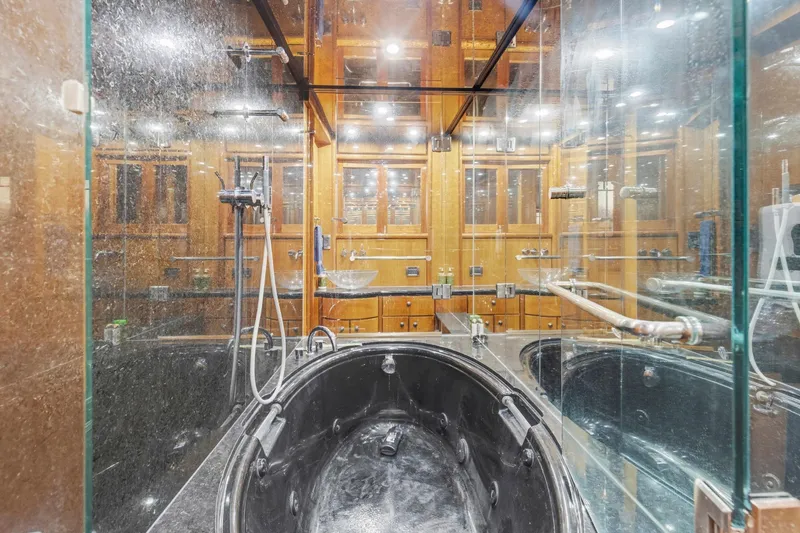 Slide: The Image of Luxurious bathroom with glass shower and black tub in 2004 Queenship 76 Baretta yacht. - 17