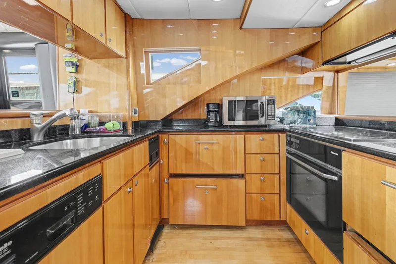 Slide: The Image of Luxurious kitchen interior of 2004 Queenship 76 Baretta yacht with modern appliances and wood cabinetry. - 24
