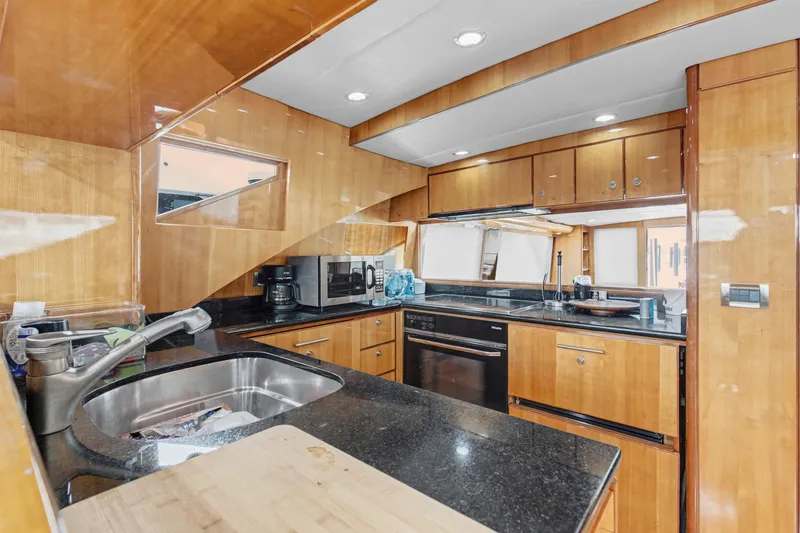 Slide: The Image of Luxurious kitchen interior of 2004 Queenship 76 Baretta yacht with modern appliances and wood finish. - 25