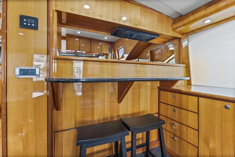 Slide: The Image of Luxurious 2004 Queenship 76 Baretta yacht interior with wooden cabinetry and bar stools. - 29