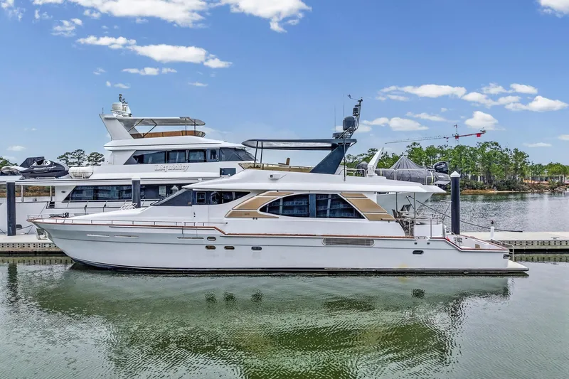 Slide: The Image of 2004 Queenship 76 Baretta yacht docked in a serene marina setting. - 3