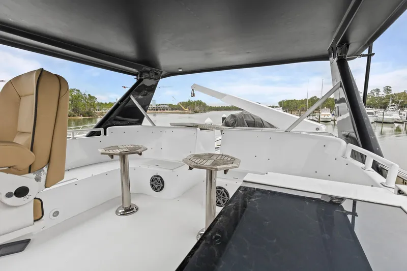 Slide: The Image of Luxurious 2004 Queenship 76 Baretta yacht interior with seating and tables, docked at marina. - 31