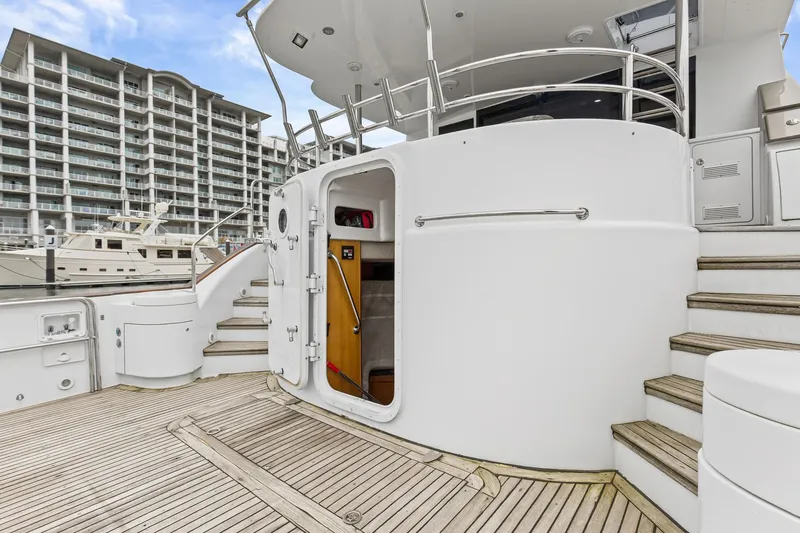 Slide: The Image of Luxury yacht deck of 2004 Queenship 76 Baretta, featuring elegant wood and modern design. - 37