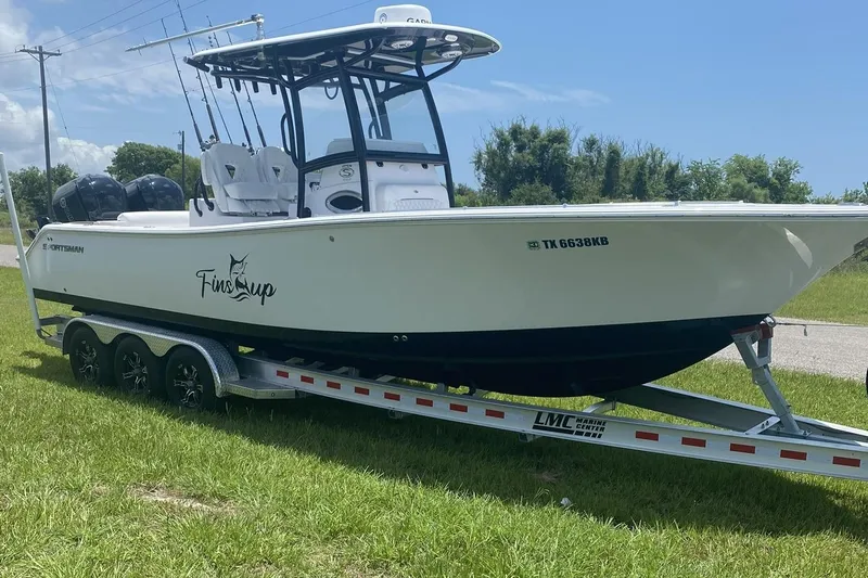 Slide: The Image of 2021 Sportsman Open 282 Center Console boat on trailer, parked on grass. - 0