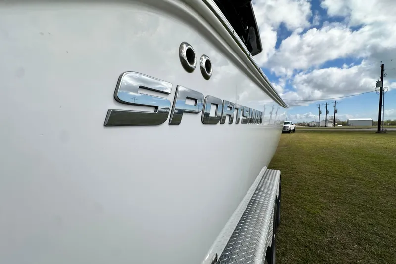 Slide: The Image of 2021 Sportsman Open 282 Center Console boat side view with logo, under a cloudy sky. - 13