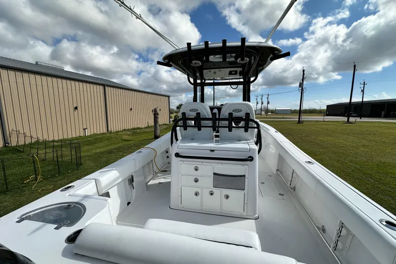 Slide: The Image of 2021 Sportsman Open 282 Center Console boat with dual seating and storage, under a cloudy sky. - 16
