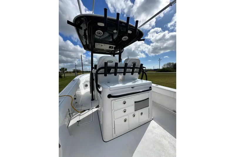 Slide: The Image of 2021 Sportsman Open 282 Center Console boat with seating and storage under a blue sky. - 21
