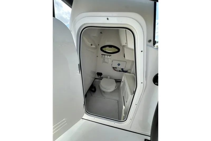Slide: The Image of 2021 Sportsman Open 282 Center Console boat interior with compact marine toilet. - 35