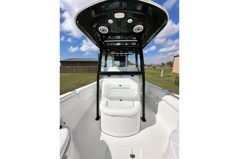 Slide: The Image of 2021 Sportsman Open 282 Center Console boat with seating and T-top under blue sky. - 37