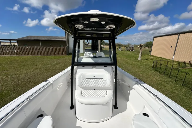 Slide: The Image of 2021 Sportsman Open 282 Center Console boat with T-top, white seating, and clear sky background. - 39