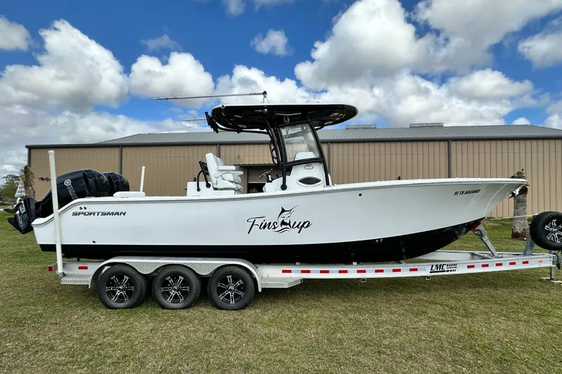 Slide: The Image of 2021 Sportsman Open 282 Center Console boat on trailer, parked outdoors under cloudy sky. - 4