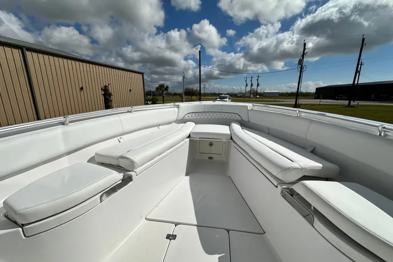 Slide: The Image of 2021 Sportsman Open 282 Center Console boat interior with white seating under cloudy sky. - 40