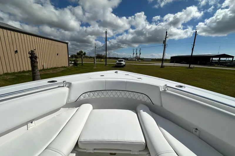Slide: The Image of 2021 Sportsman Open 282 Center Console boat with white seating, parked outdoors under cloudy sky. - 47