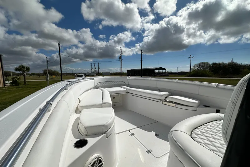 Slide: The Image of 2021 Sportsman Open 282 Center Console boat interior with white seating under a cloudy sky. - 48