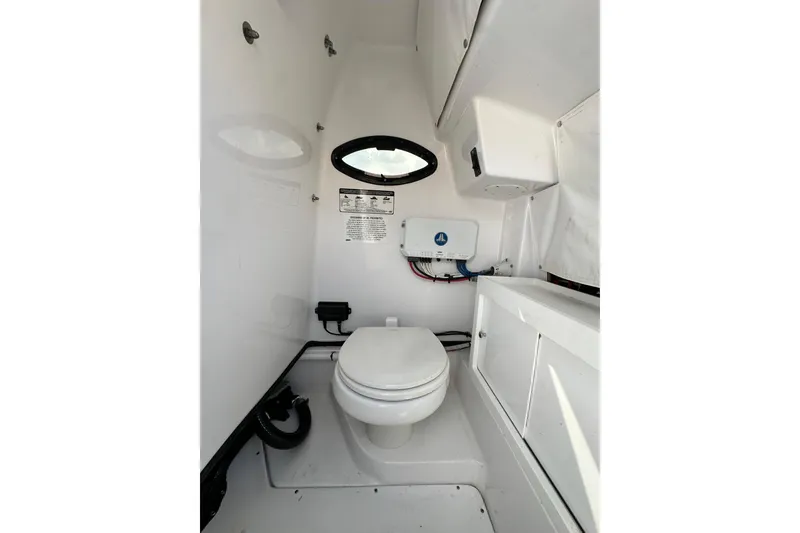 Slide: The Image of 2021 Sportsman Open 282 Center Console boat interior with toilet and storage. - 50