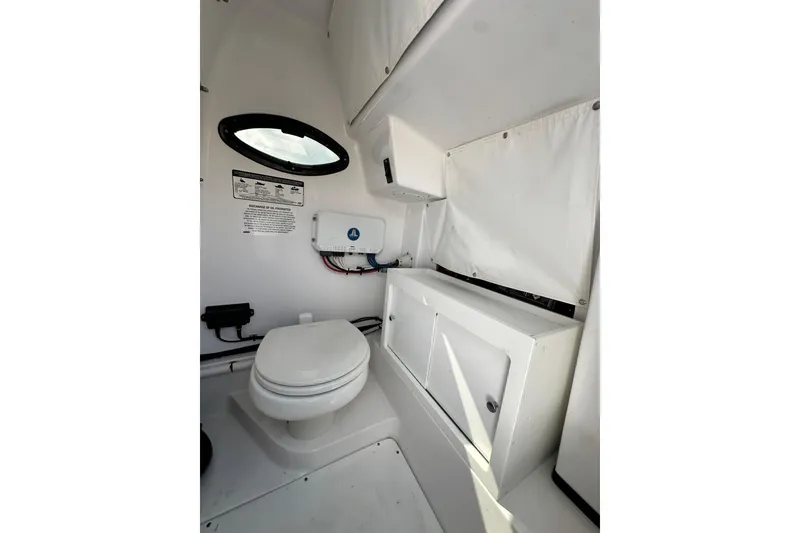 Slide: The Image of 2021 Sportsman Open 282 Center Console boat interior with toilet and storage. - 51
