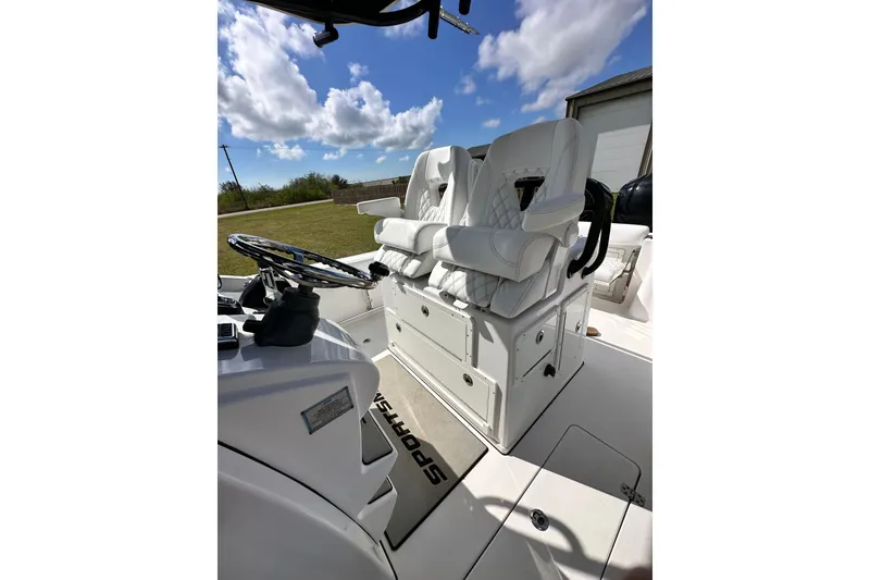 Slide: The Image of 2021 Sportsman Open 282 Center Console boat interior with white seating and steering wheel. - 52