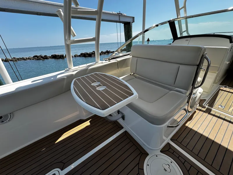 Slide: The Image of 2019 Boston Whaler 270 Vantage boat interior with seating and table, overlooking the ocean. - 19