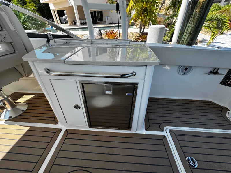 Slide: The Image of 2019 Boston Whaler 270 Vantage boat interior with kitchenette and wooden flooring. - 20