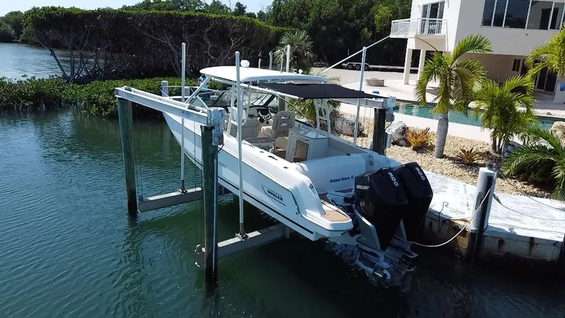 Slide: The Image of 2019 Boston Whaler 270 Vantage boat docked near waterfront home with lush greenery. - 3
