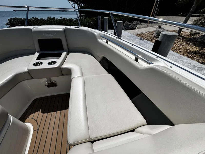 Slide: The Image of 2019 Boston Whaler 270 Vantage boat interior with cushioned seating and cup holders. - 30