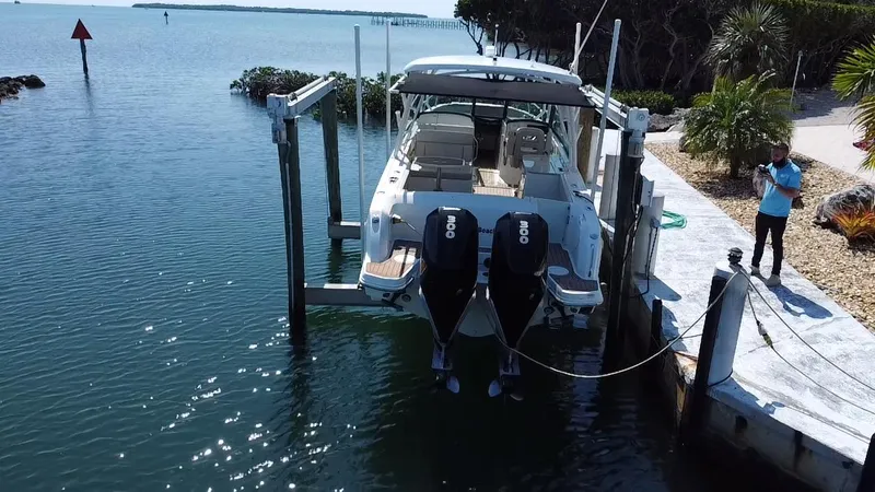 Slide: The Image of 2019 Boston Whaler 270 Vantage boat docked with dual engines in a scenic waterfront setting. - 4