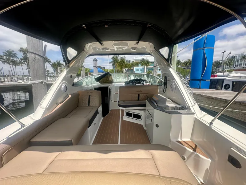 Slide: The Image of 2012 Sea Ray 310 Sundancer interior with seating and helm, docked at marina. - 11