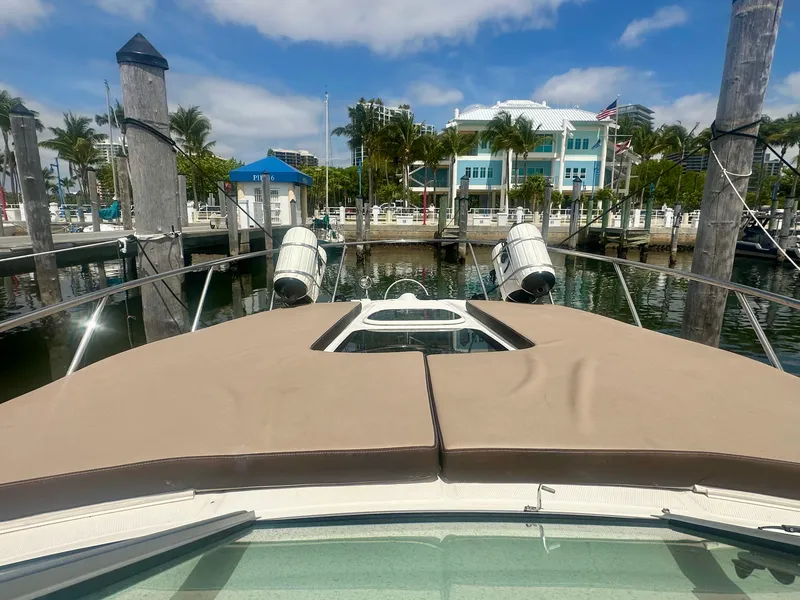 Slide: The Image of 2012 Sea Ray 310 Sundancer docked at marina with scenic waterfront view. - 13
