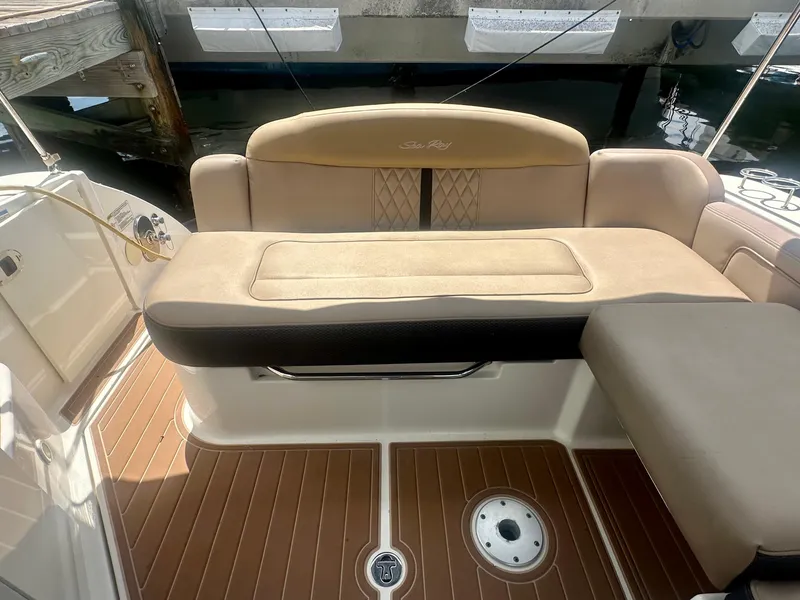 Slide: The Image of 2012 Sea Ray 310 Sundancer boat interior with cushioned seating and teak flooring. - 18