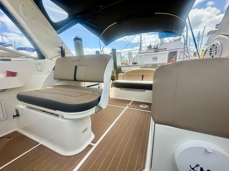 Slide: The Image of 2012 Sea Ray 310 Sundancer interior with beige seating and wood-style flooring. - 19