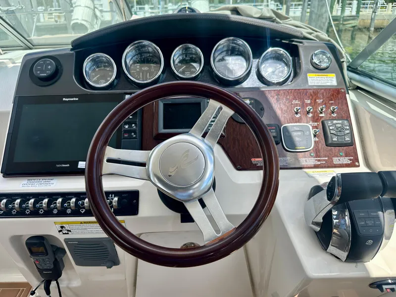 Slide: The Image of Cockpit of 2012 Sea Ray 310 Sundancer with steering wheel and control panel. - 21