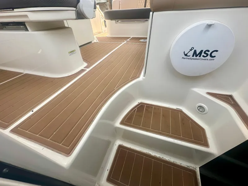 Slide: The Image of 2012 Sea Ray 310 Sundancer boat deck with brown flooring and MSC logo. - 28