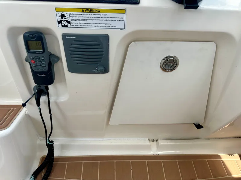 Slide: The Image of 2012 Sea Ray 310 Sundancer boat control panel with radio and storage compartment. - 32