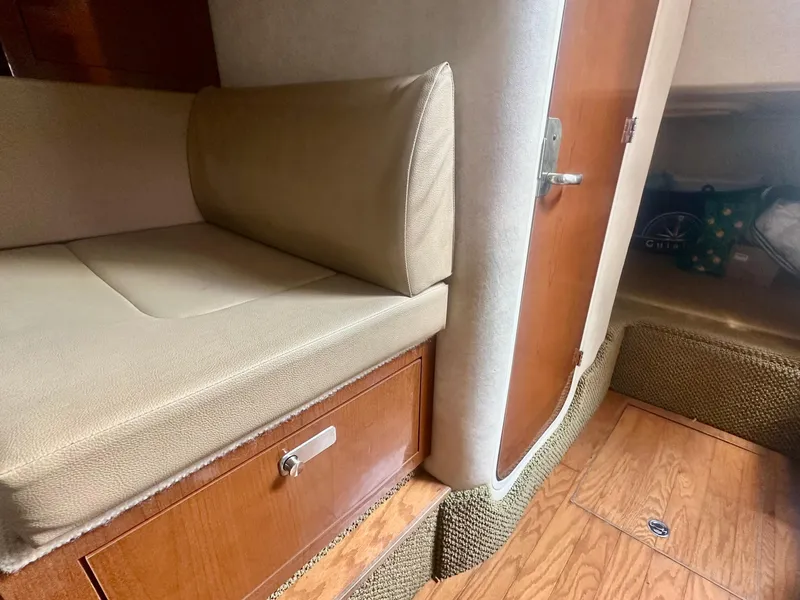 Slide: The Image of Interior of 2012 Sea Ray 310 Sundancer with beige seating and wooden cabinetry. - 39