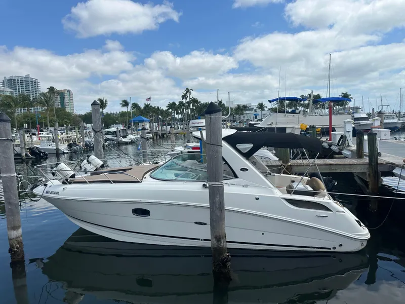 Slide: The Image of 2012 Sea Ray 310 Sundancer docked at a marina under a partly cloudy sky. - 5
