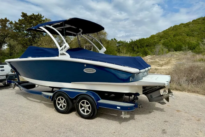 Slide: The Image of 2016 Cobalt CS3 boat on trailer, blue cover, parked outdoors. - 17