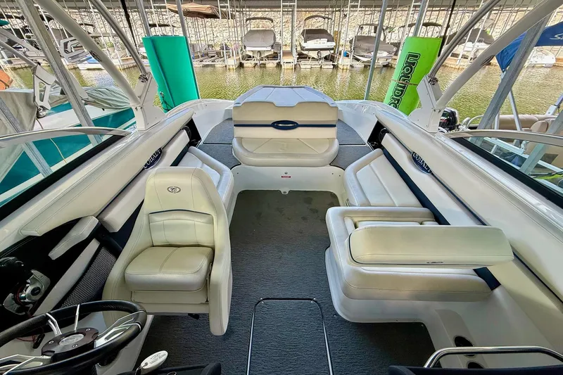 Slide: The Image of 2016 Cobalt CS3 boat interior with white seating and steering wheel, docked at marina. - 21