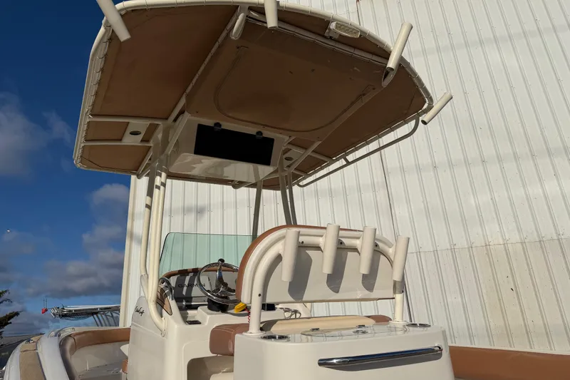Slide: The Image of 2013 Chris-Craft Catalina 23 boat with T-top and rod holders, docked near a building. - 17