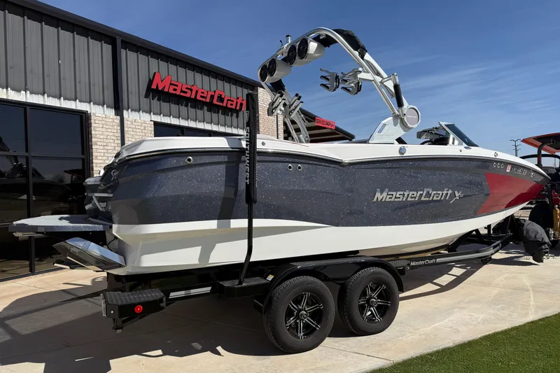 Slide: The Image of 2021 MasterCraft XStar boat on trailer outside dealership, showcasing sleek design and modern features. - 3