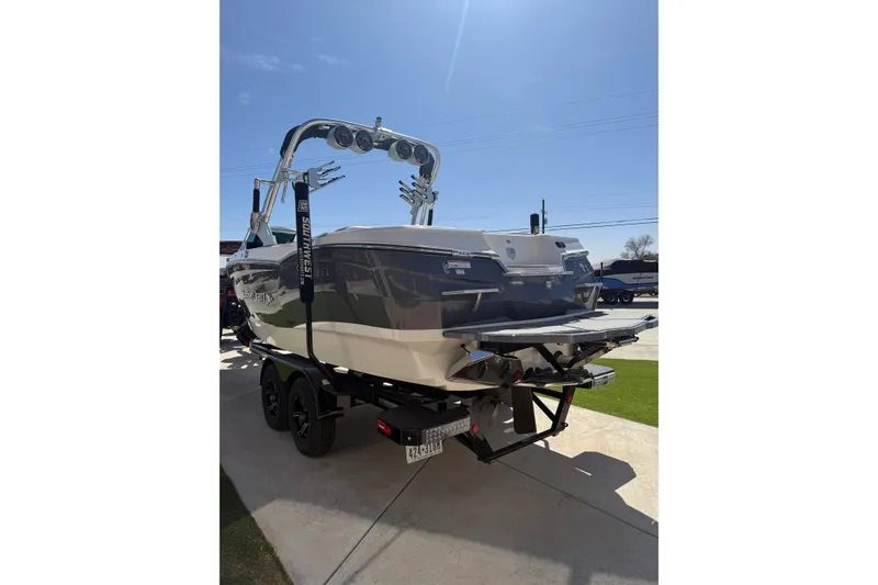 Slide: The Image of 2021 MasterCraft XStar boat on trailer under clear blue sky. - 6