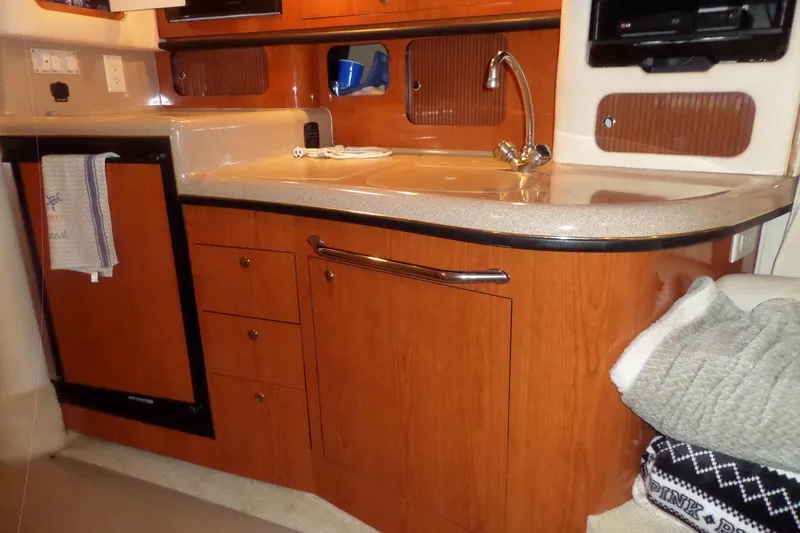 Slide: The Image of 2001 Sea Ray 340 Sundancer cabin kitchen with wood cabinetry and countertop sink. - 11