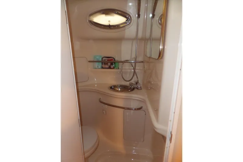Slide: The Image of 2001 Sea Ray 340 Sundancer bathroom with shower, sink, and storage shelves. - 17
