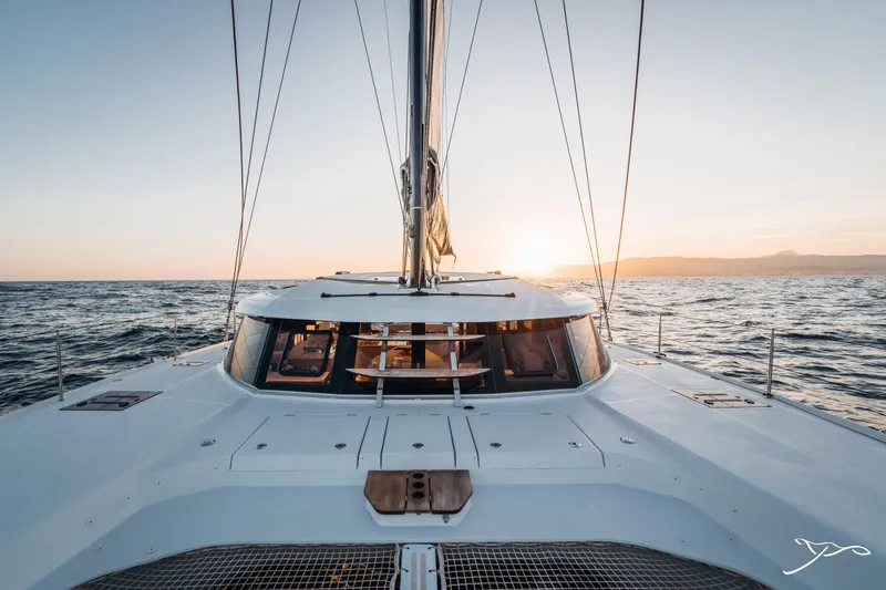 Slide: The Image of 2025 Nautitech 44 Open catamaran sailing at sunset on open sea. - 0